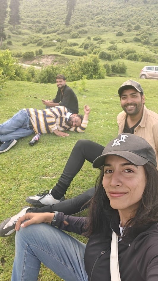 Varuna and friends relaxing on green grass in Kashmir hills at the Sitaharan location