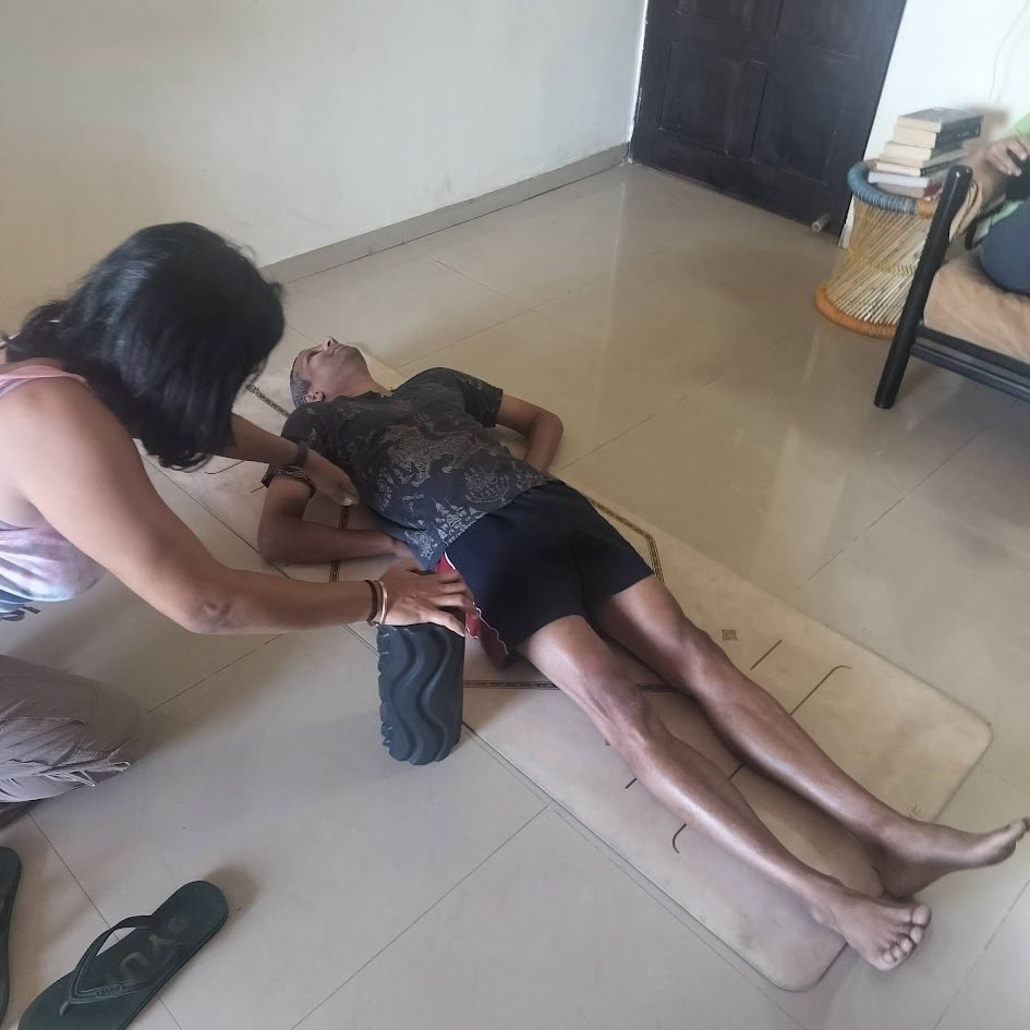 Varuna Shunglu working on a student's lower back with a foam roller — postural correction at La Waha