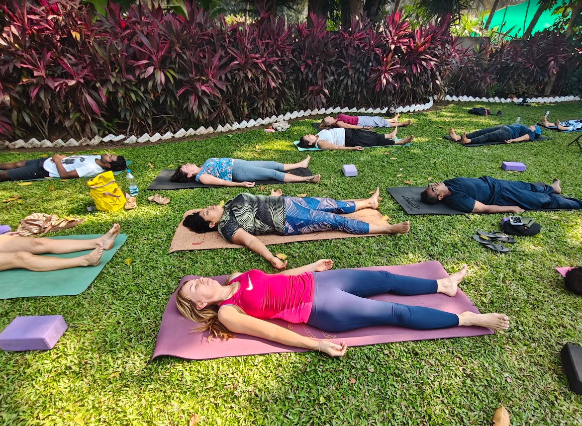 A group Savasana relaxation session on the grass at La Waha, South Goa
